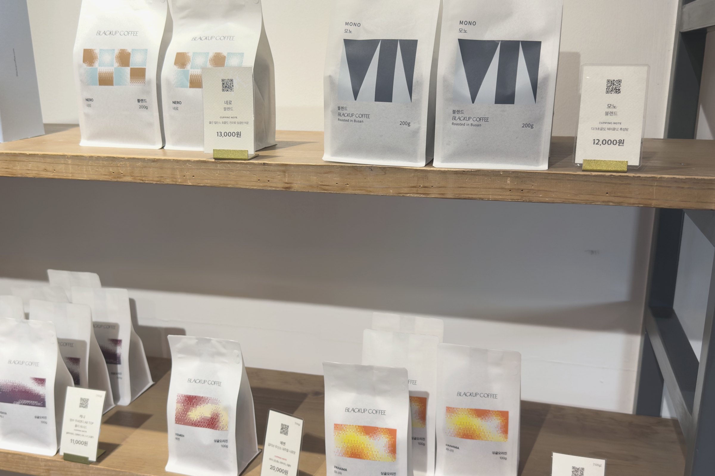 Two shelves of coffee bags with price cards